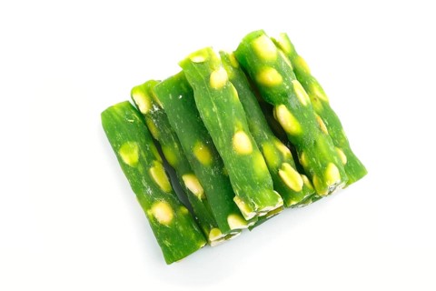 Green traditional turkish delight (rahat lokum) with peanuts isolated on white background. top