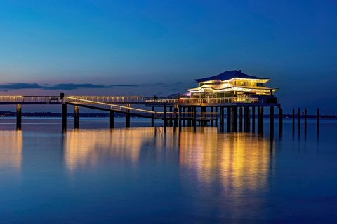 Blue hour at the illuminated Mikado house on the beach of Timmendorf on the Baltic Sea as a long