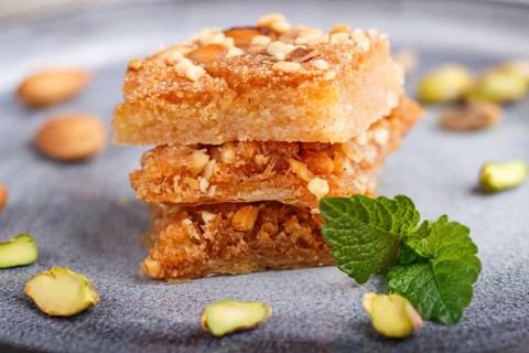 Traditional arabic sweets in gray ceramic plate on a gray concrete background. side view, close up,