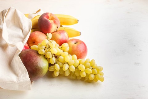 Fruits in reusable cotton textile white bag. Zero waste shopping, storage and recycling concept,