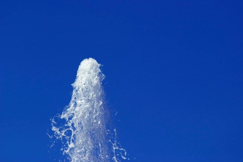 Water from a fountain in the blue sky