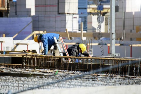 Construction work on the foundations of a large apartment building. The construction workers are