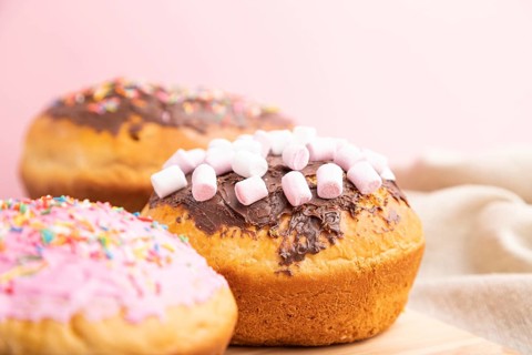 Homemade glazed and decorated easter pies with chocolate eggs and rabbits on a gray and pink