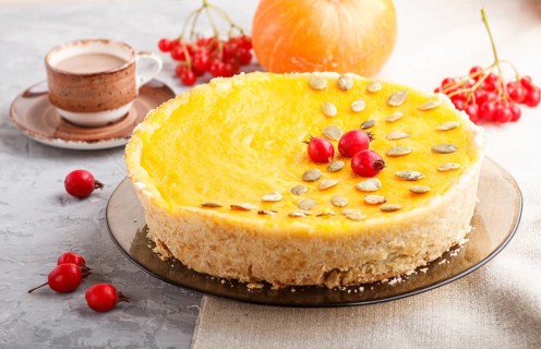 Traditional american sweet pumpkin pie decorated with hawthorn red berries and pumpkin seeds with