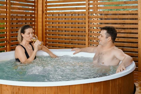 Couple in love spending time together in outdoor hot tub enjoying free time
