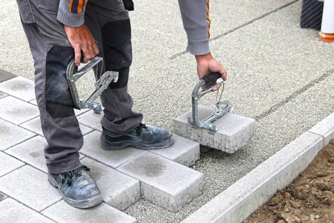 Worker lays paving stones