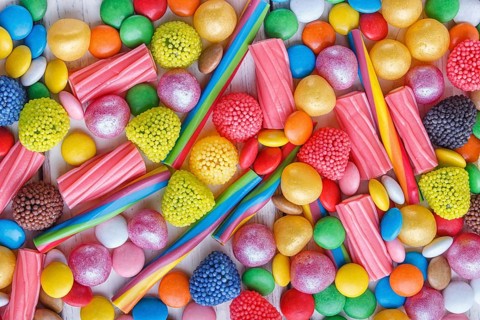 Mixed multicolored candies on white wooden background. top view, flat lay