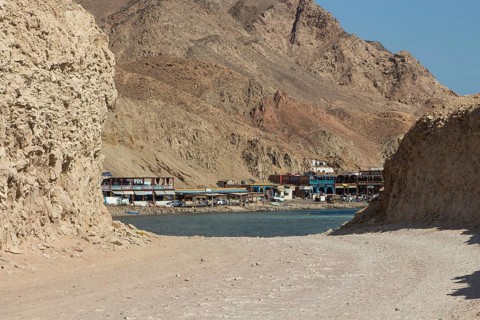 The coastline of the Red Sea with small resorts and the mountains in the background. Coral reef