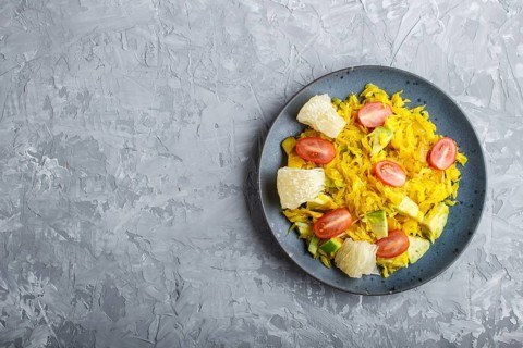 Fried pomelo with tomatoes and avocado on gray concrete background. Top view, copy space, myanmar