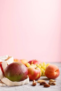 Fruits in reusable cotton textile white bag. Zero waste shopping, storage and recycling concept,