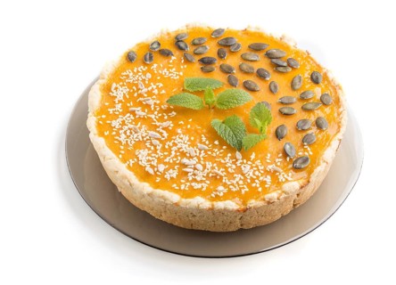 Traditional american sweet pumpkin pie decorated with mint, sesame and pumpkin seeds isolated