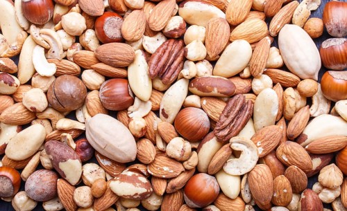 Background and texture made from different kinds of nuts. hazelnut, brazil nut, almond, pumpkin