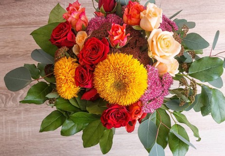 Bouquet of sunflowers and roses on a wooden background. floristic composition