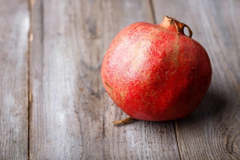 Ripe garnet on a rustic wooden background