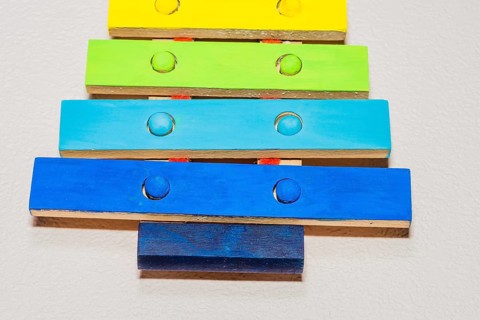 Closeup of small wooden toy xylophone hand painted in bright primary colors