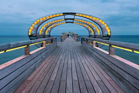 Long exposure of the Kellenhusen pier on the Baltic Sea with yellow illuminated arcades