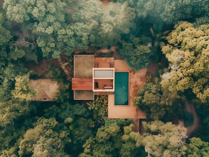 Aerial shot of a secluded house with a swimming pool surrounded by dense greenery, Playa del Carmen