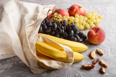 Fruits in reusable cotton textile white bag. Zero waste shopping, storage and recycling concept,