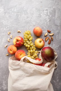Fruits in reusable cotton textile white bag. Zero waste shopping, storage and recycling concept,