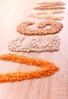 Word Vegan made of lentils, buckwheat, beans, rice and chickpeas on a wooden background