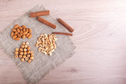 Cinnamon, almonds, hazelnuts, cashew on a linen napkin. Still life. Closeup. copy space