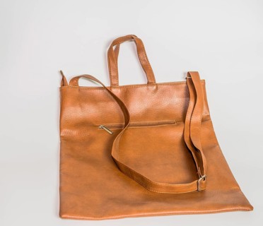 Brown leather shoulder bag with front zipper pocket isolated on white background