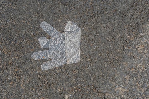 Plastic disposable glove discarded on street pavement in South Korea