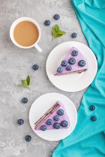 Homemade cake with souffle cream and blueberry jam with cup of coffee and fresh blueberries on a