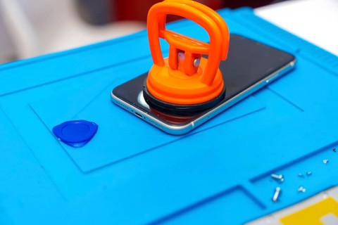 Close-up photo of a suction cup pressing the screen of a mobile to attach it in the desk of a