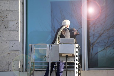Workers cleaning glass in an office building