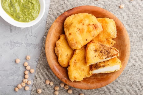 Traditional indian food paneer pakora in wooden plate with mint chutney on a gray concrete