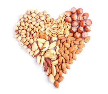 Heart made from different kinds of nuts isolated on white background. hazelnut, brazil nut, almond,
