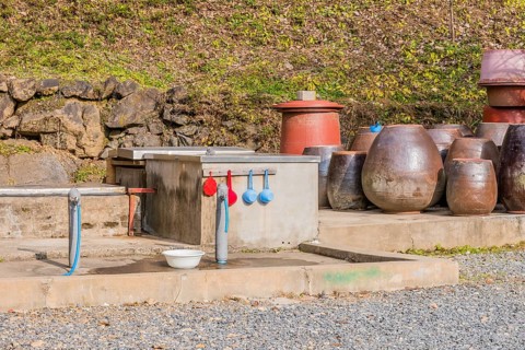 Public use water faucets with plastic dippers and bowl for use by hikers and travelers visiting the