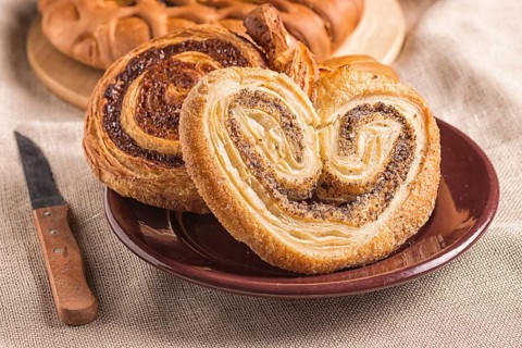 Sweet buns on a wooden board and linen tablecloth