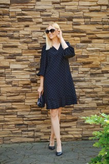Trendy fashionable businesswoman in loose black dress and sunglasses walking outdoor