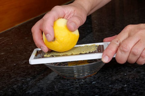 Preparation lemon sauce for fillet of Dreisam salmon with wild rice, grating lemon peel, kitchen