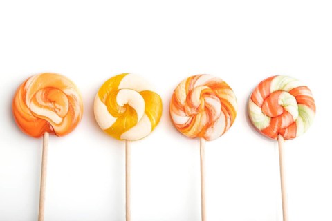 Four lollipop candies isolated on white background. close up, top view, flat lay