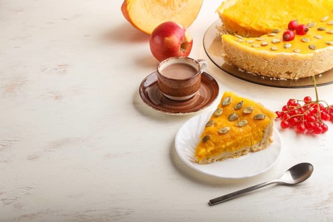 Traditional american sweet pumpkin pie decorated with hawthorn red berries and pumpkin seeds with