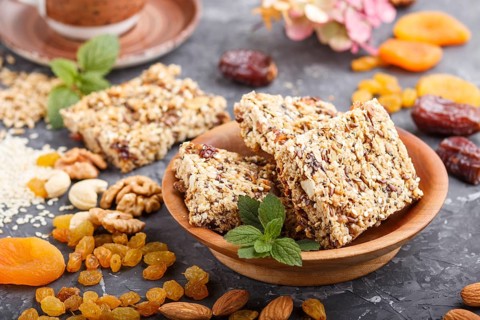 Homemade granola from oat flakes, dates, dried apricots, raisins, nuts with a cup of coffee on a
