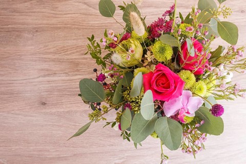 Composition of autumn flowers in a hat box on a wooden background. floristic arrangement. copy