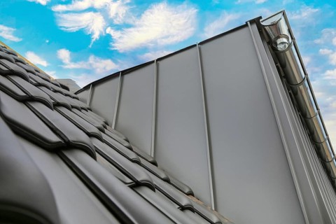 New tiling of a tiled roof. The new dormer window with aluminium cladding is already finished