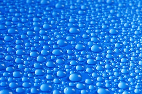 Many small water drops on a blue surface