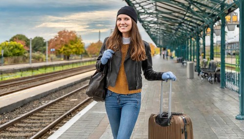 AI generated, A young blonde woman wants to travel and waits for the train at the station, 20, 25,