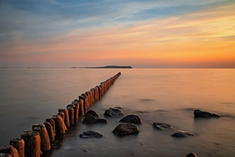 Sunset in Dranske on Ruegen with a view over the groynes to Hiddensee