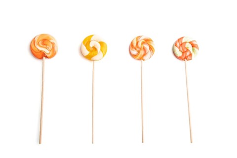 Four lollipop candies isolated on white background. close up, top view, flat lay