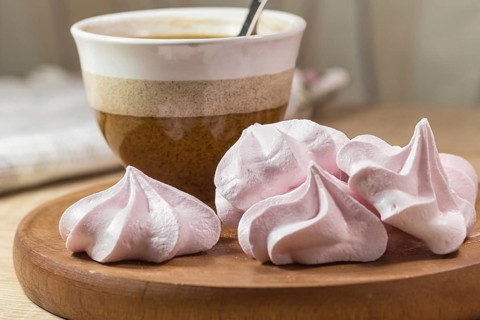 Chewing marshmallows, meringue and coffee cup on a wooden board and linen tablecloth