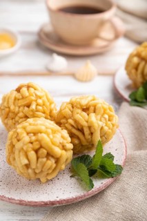 Traditional Tatar candy chak-chak made of dough and honey with cup of coffee on a white wooden