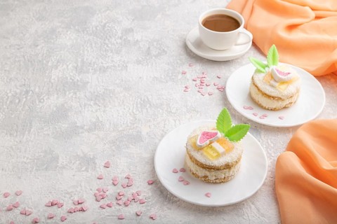 Decorated cake with milk and coconut cream with cup of coffee on a gray concrete background and