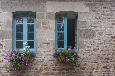 Two windows in a typical granite house, floral decoration, Dinan old town, Brittany, France, Europe