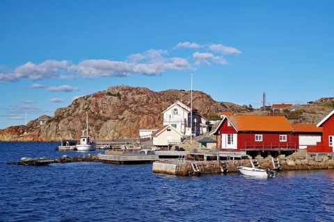 Colourful fishermen's huts nestled against high rocks, small fishing boat, autumn, Vaestra
